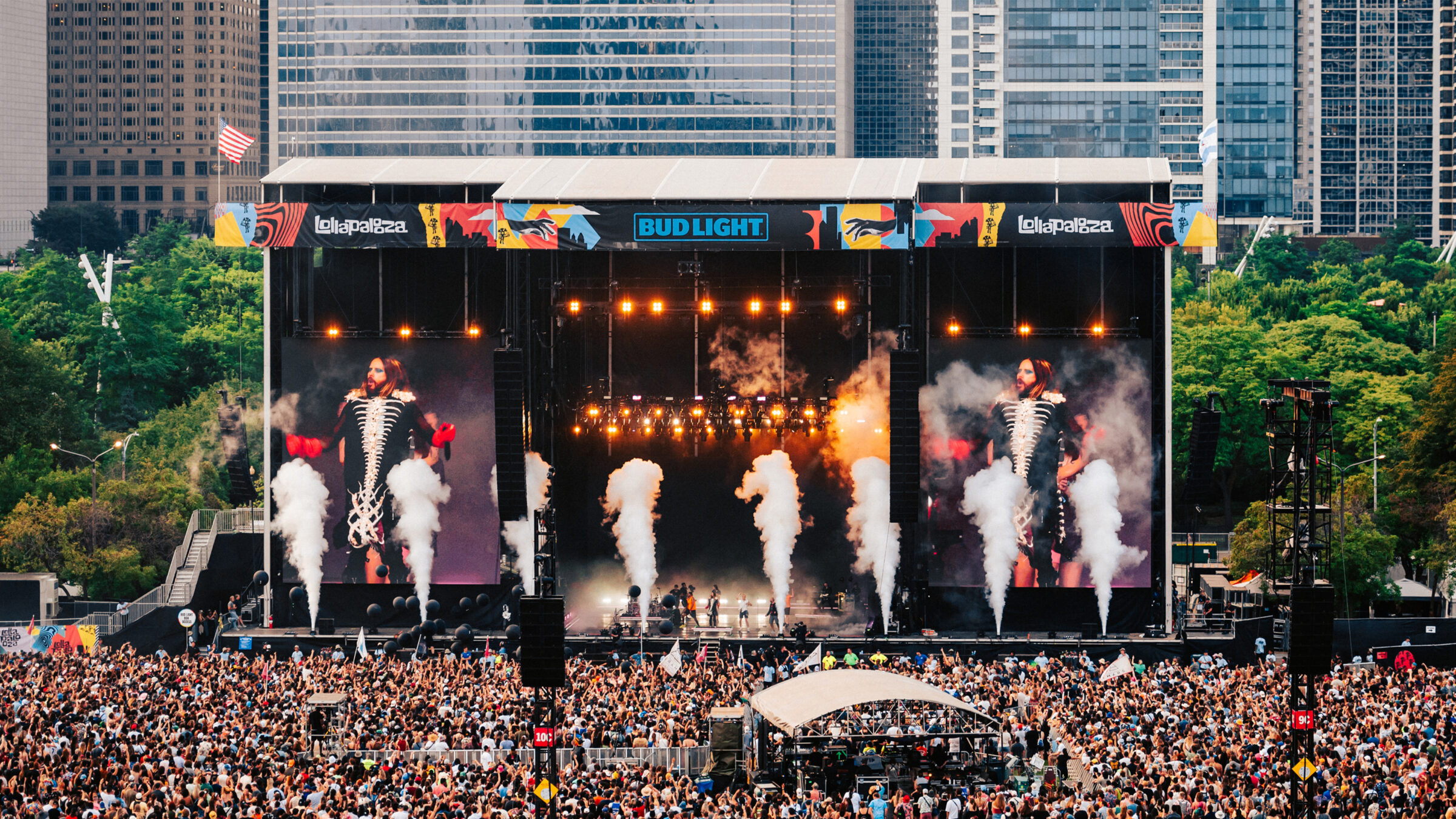artist performing on the main stage with a large crowd of people in front