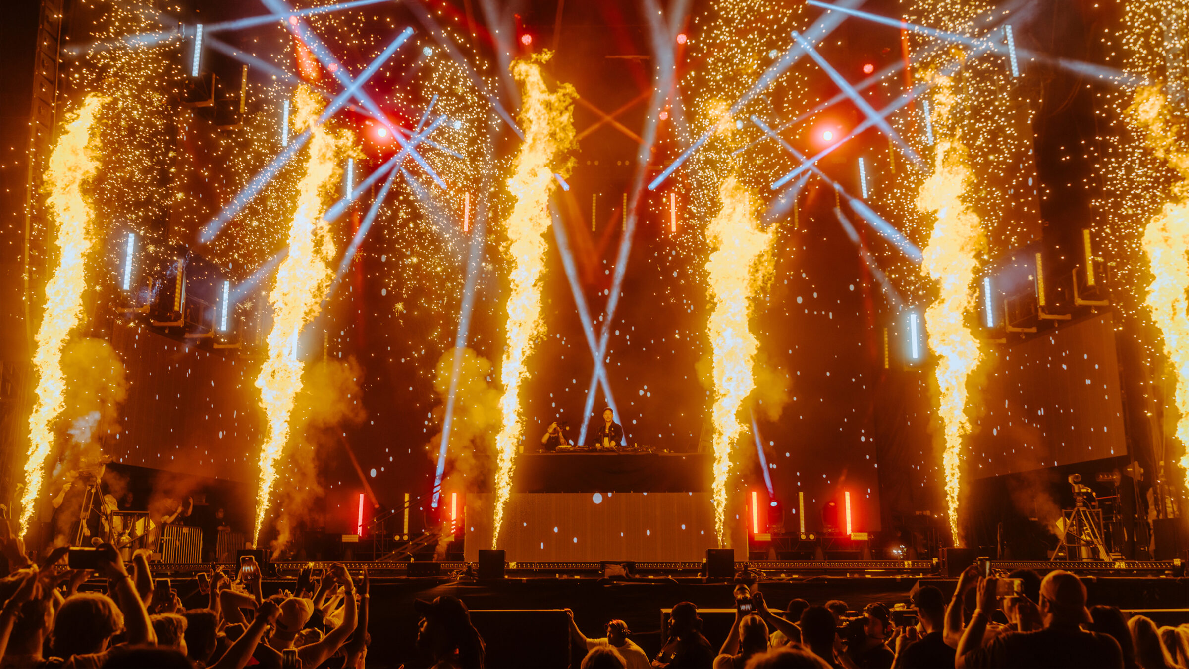 dj performing on stage with pyrotechnics