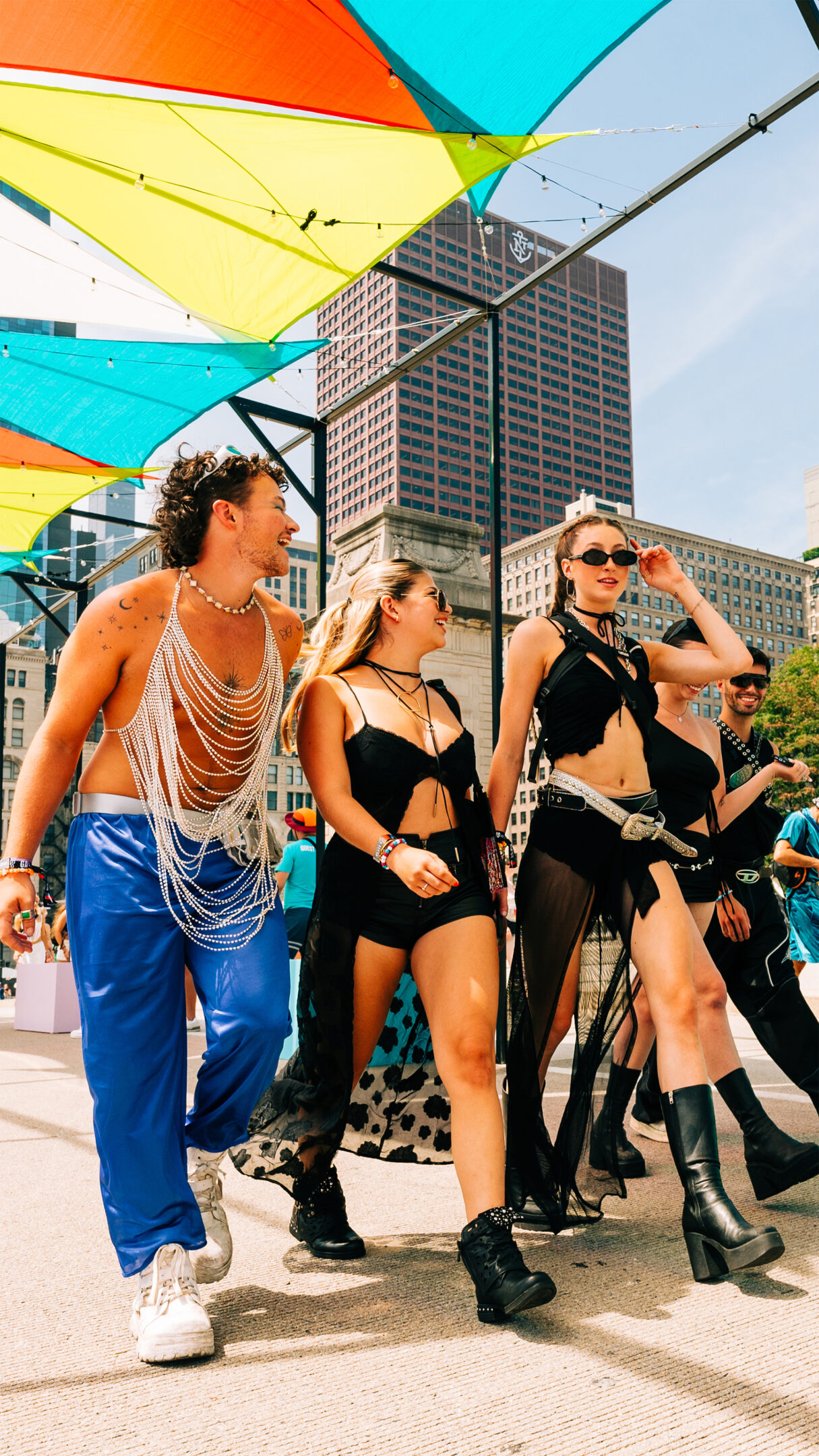 three people in stylish festival outfits walking