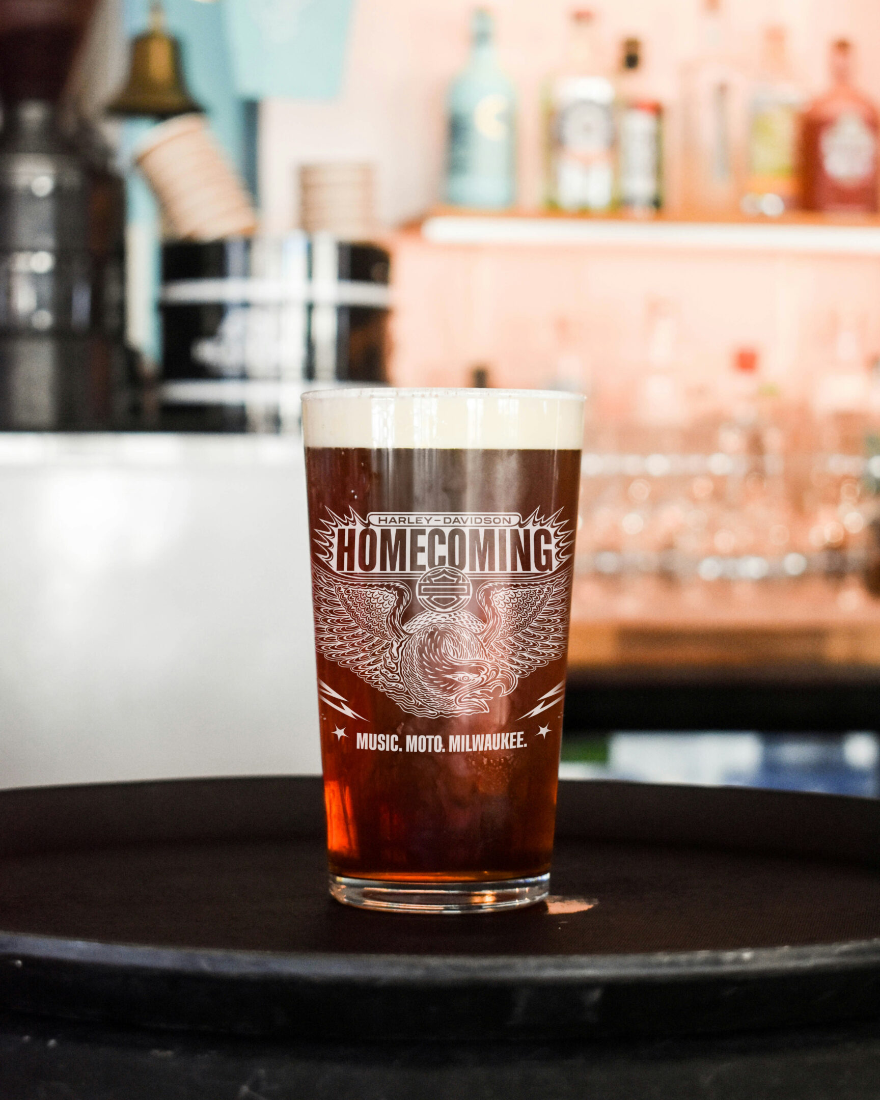 beer pint glass with the harley-davidson homecoming logo, illustrated eagle and "music. moto. milwaukee."